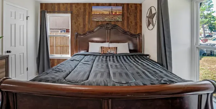 Cozy rustic bedroom with king bed, wood accents, and bright natural light