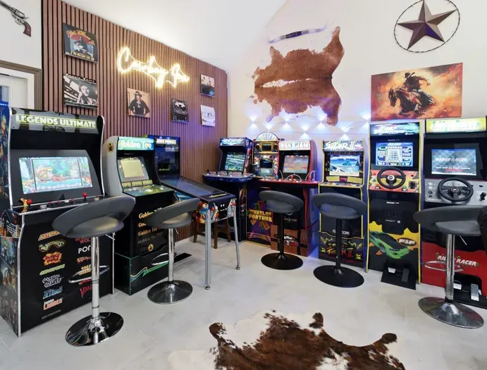 Retro arcade game room with classic machines, bar seating, and bold Western flair
