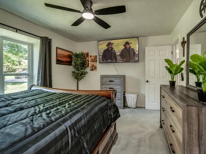 Cozy bedroom with TV, dresser storage, and bright natural light