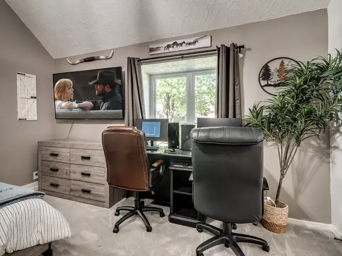 Cozy bedroom workspace with natural light, TV, and rustic Western charm