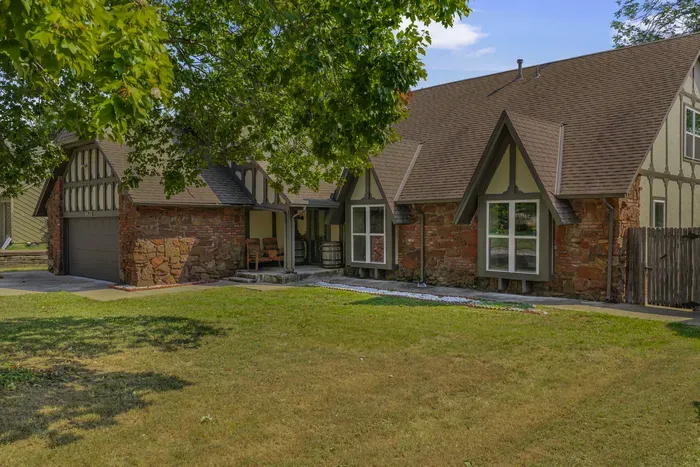 Charming Tudor-style home with stone accents and shady front lawn