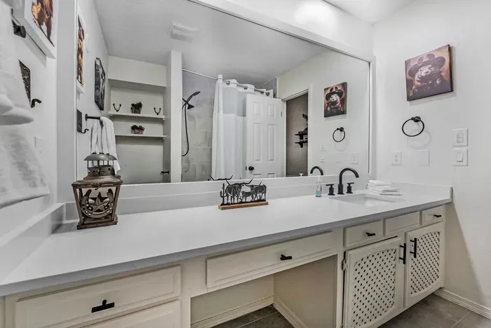 Spacious bath with oversized vanity, large mirror, and stylish black accents