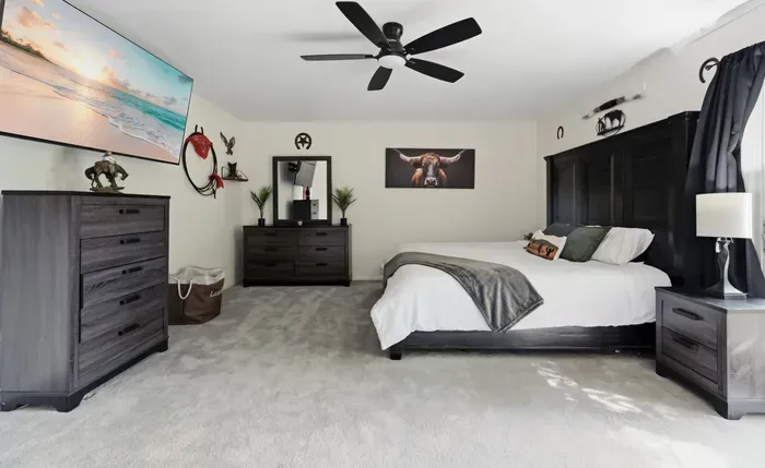 Spacious king bedroom with dark wood accents and bright, inviting style