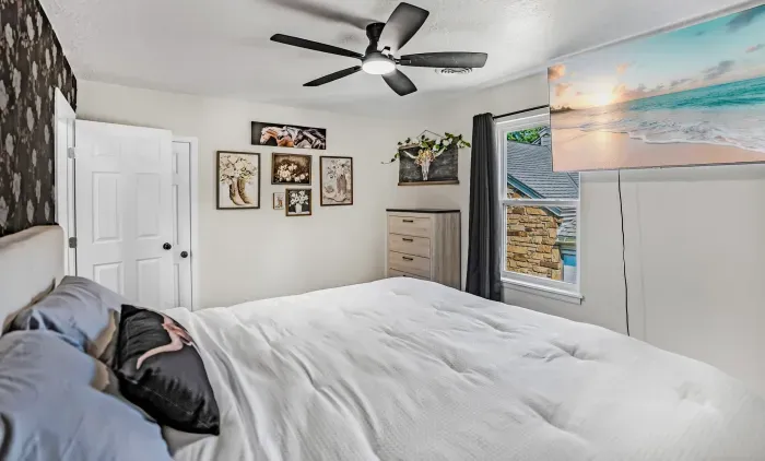 Cozy bedroom with plush bedding, TV, and bright natural light