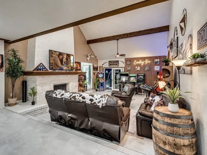 Rustic great room with stone fireplace, vaulted ceilings & arcade games