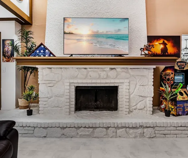 Cozy stone fireplace, big-screen TV, and arcade fun in the living room