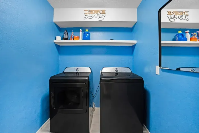 Convenient in-home laundry room with modern washer, dryer, and storage