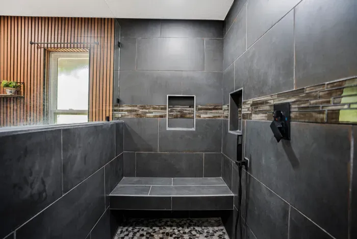 Spa-style walk-in shower with bench, niches, and modern tile design