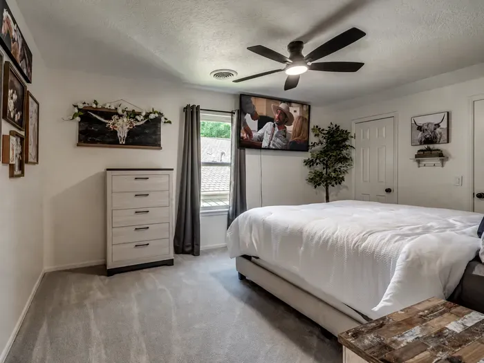 Cozy bedroom with plush king bed, TV, and stylish rustic touches