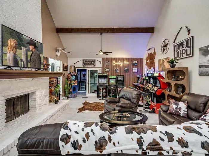 Western-themed game lounge with fireplace, leather seating, and arcade fun