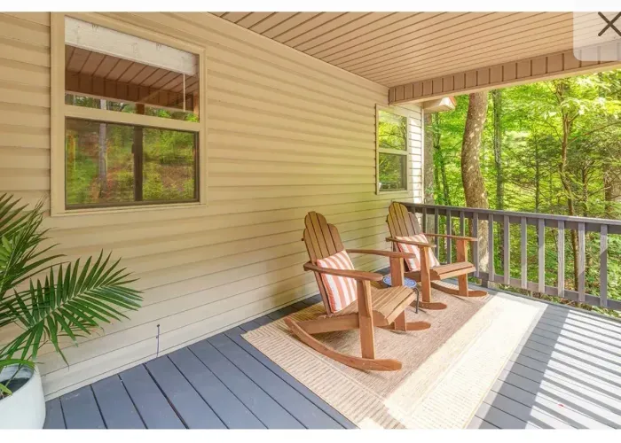 Covered forest-view porch with rocking chairs—relax and unwind.