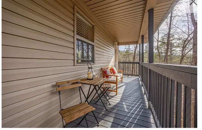 Covered balcony with bistro set & forest views—perfect coffee spot