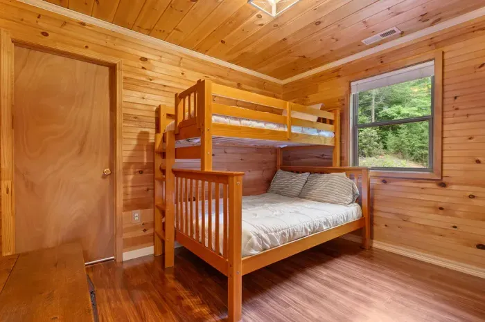Cozy cabin bunk room with wooded views—great for families or groups