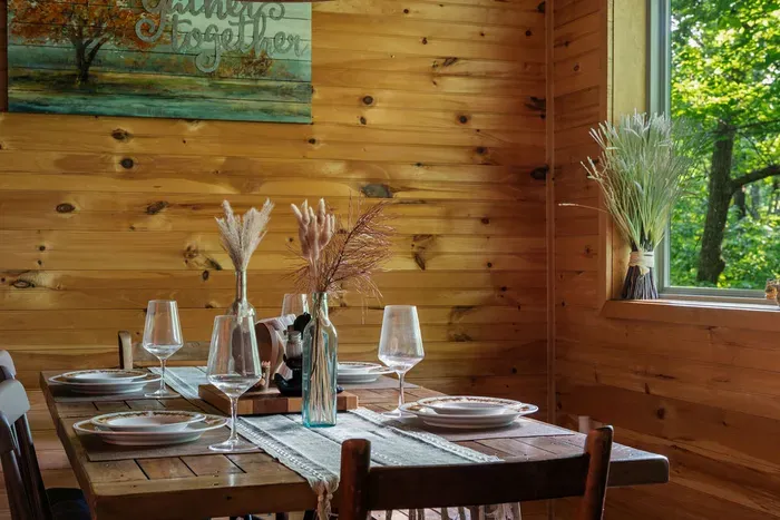 Cozy wood-lined dining nook with forest views and rustic cabin charm