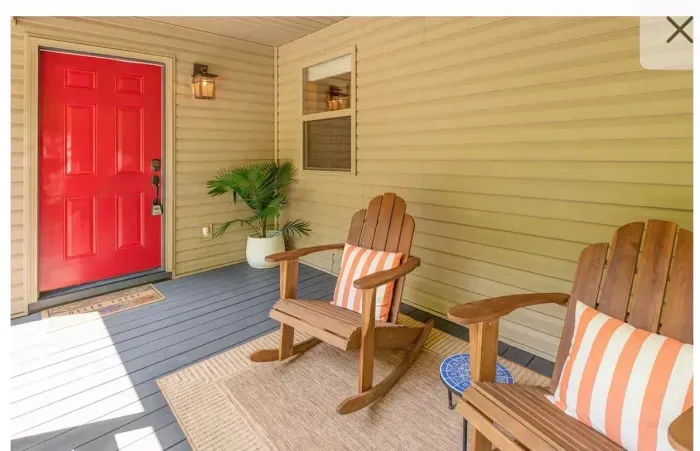 Cozy covered porch with rocking chairs and bold red door