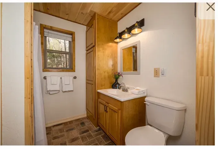 Cozy cabin bath with wood accents, ample storage, and bright vanity
