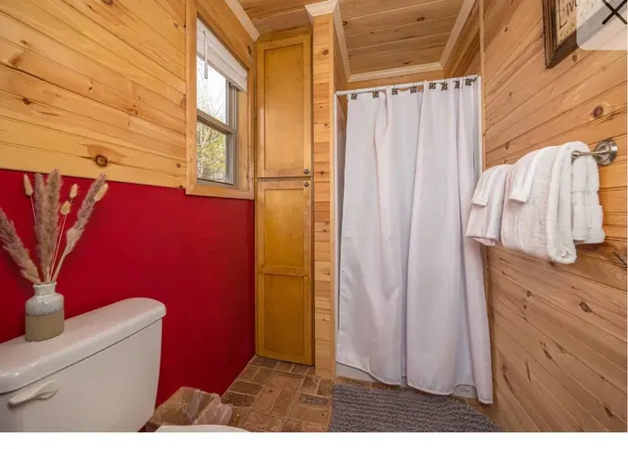 Rustic cabin bath with walk-in shower, plush towels, natural light