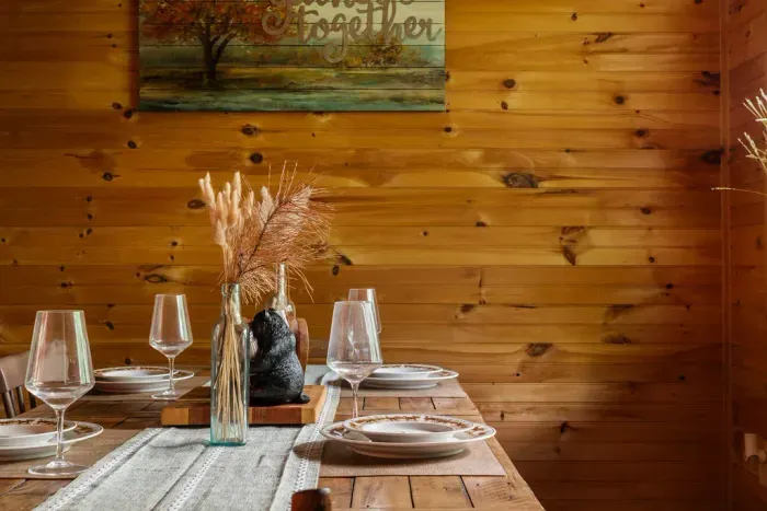 Cozy rustic dining nook with warm wood walls and a beautifully set table