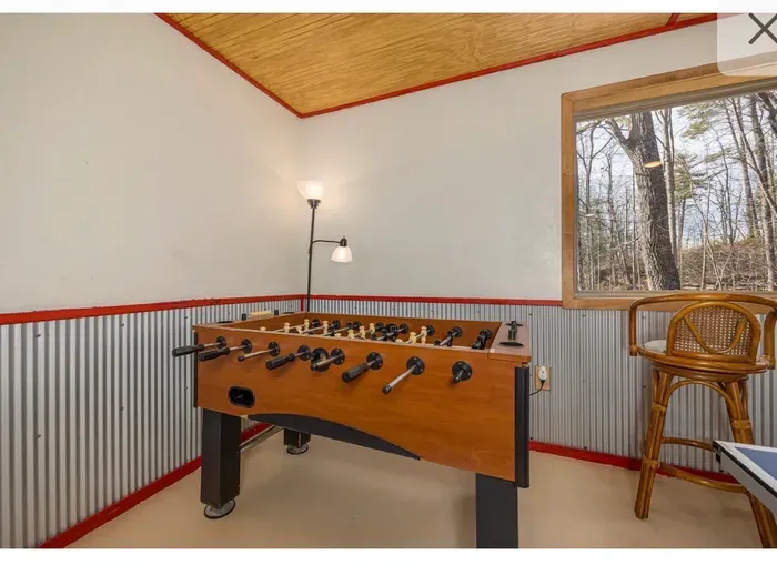 Cozy game nook with foosball, forest views, and lounge seating