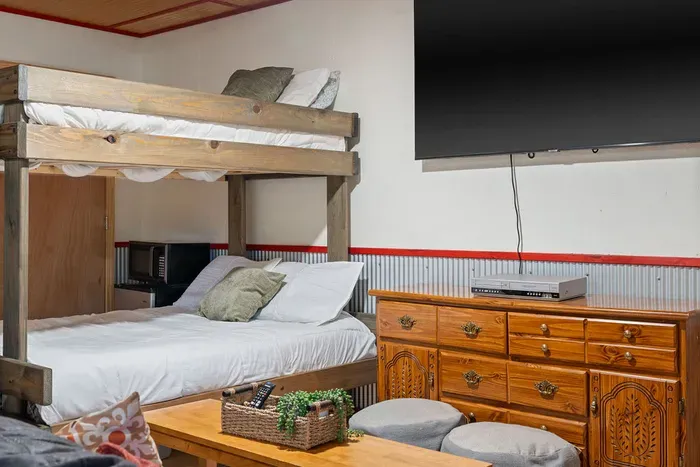 Cozy rustic bunk nook with TV and family-friendly sleeping space