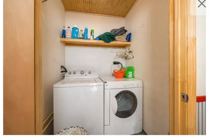 In‑unit washer & dryer with detergents, shelf storage, and hanging rod.