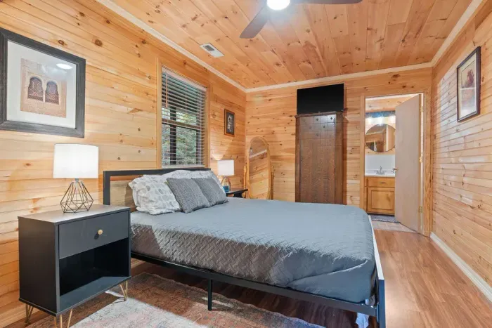 Cozy wood-paneled bedroom with en suite bath and warm cabin charm