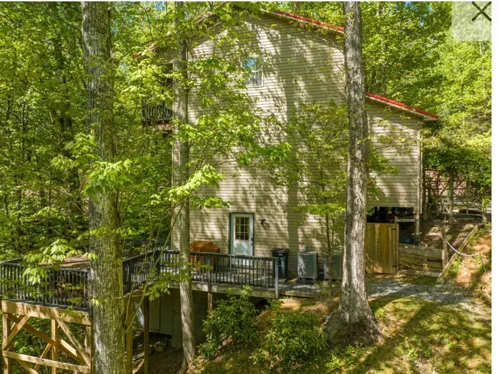 Secluded forest cabin with elevated deck, hot tub, and nature views