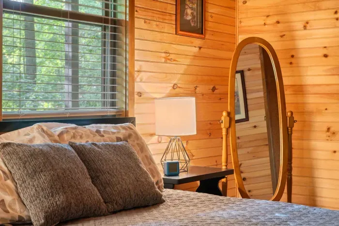Cozy wood-paneled bedroom with natural light and cabin charm