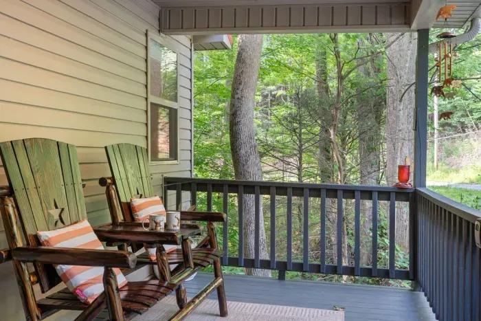 Cozy covered porch with rocking chairs and serene wooded views