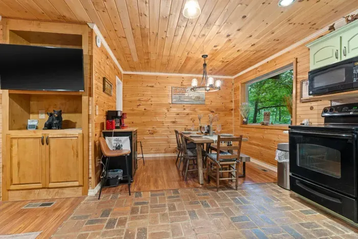 Cozy wood-lined dining area with forest views and a convenient coffee bar