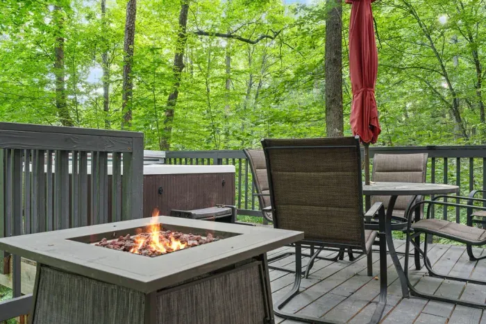 Private forest-view deck with fire pit, dining set, and relaxing hot tub
