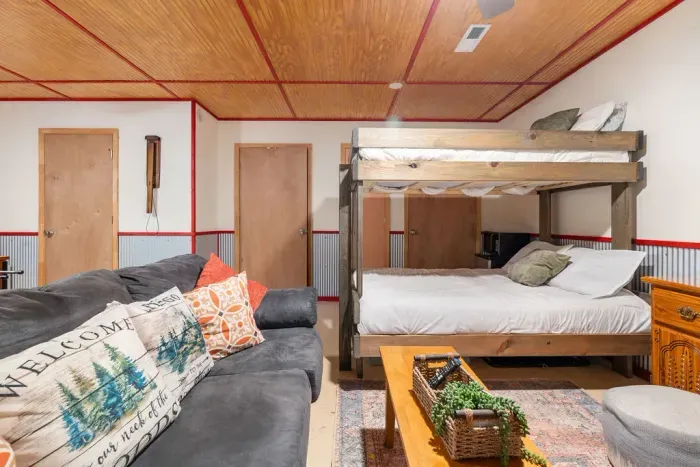 Cozy rustic bunk room with sofa seating and warm cabin-style charm