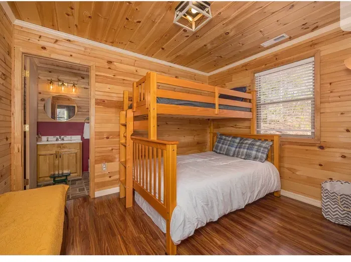 Cozy wood-paneled bunk room with ensuite bath—great for families