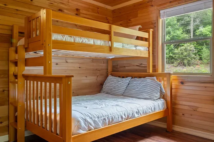 Cozy wood-paneled bunk room with forest views, perfect for families