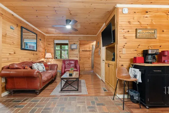 Cozy wood-paneled cabin lounge with leather seating and coffee bar