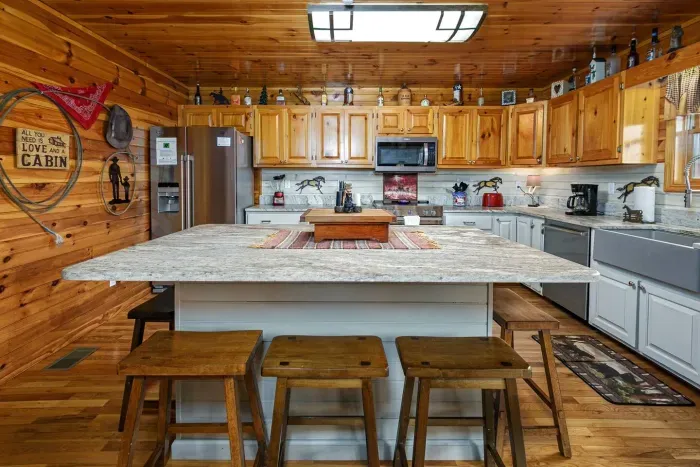 Gourmet kitchen with stainless steel appliances, island bar, quartz countertops, cowboy decor 