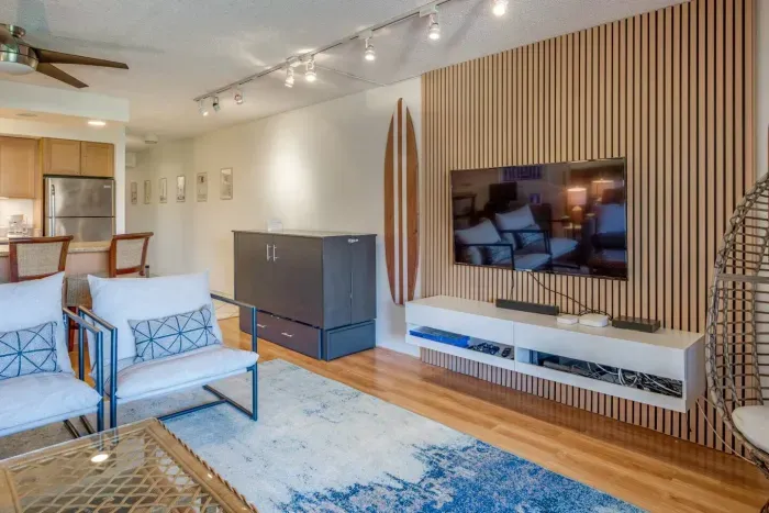 Seating area with smart TV opens into kitchen with Murphy bed and sofa sleeper 