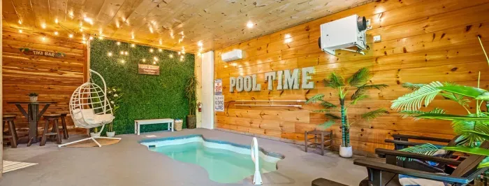 Cozy indoor plunge pool oasis with tiki bar, swing chair & lights