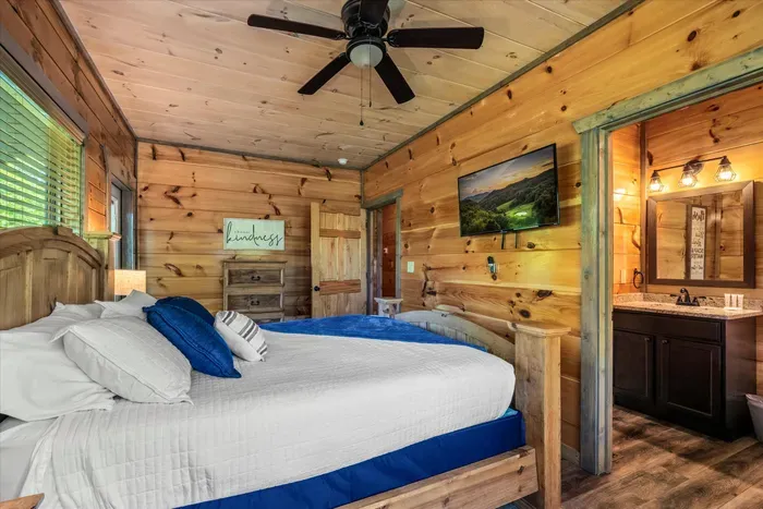Cozy king cabin suite with en-suite bath, TV, and warm wood finishes