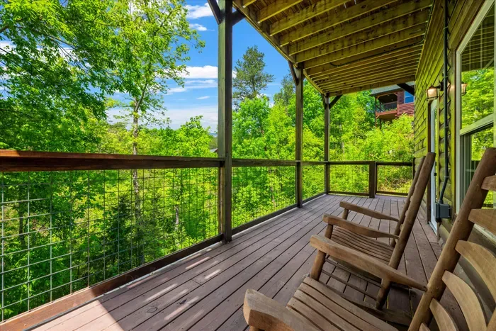 Covered deck with rocking chairs and serene forest views