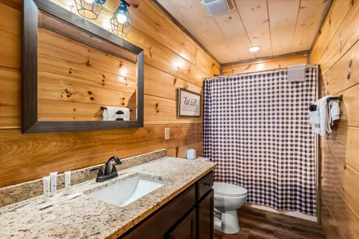 Cozy cabin bath with granite vanity, plush towels, and rustic charm