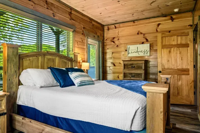 Cozy cabin bedroom with forest views, wood bed, and soft blue accents