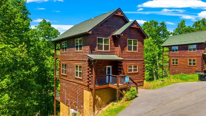Rustic multi-level log cabin with forest views and a cozy porch