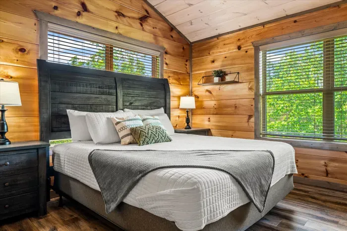 Sunny cabin bedroom with king bed, woodland views, and rustic charm