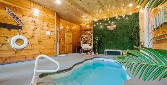 Private indoor pool oasis with string lights and hanging egg chair