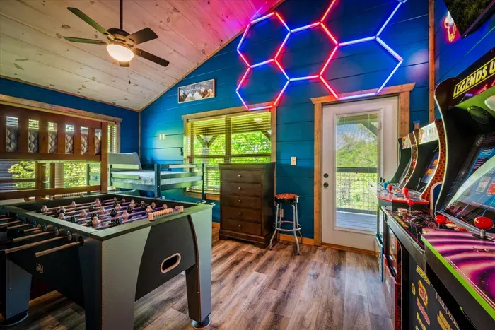Vibrant game loft: arcades, foosball, and a balcony with views.