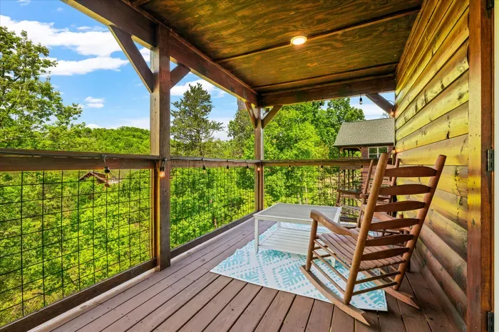 Covered deck with rocking chairs and treetop views—pure serenity.