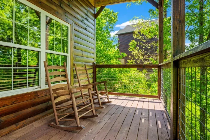 Treehouse-style porch with rocking chairs and peaceful forest views