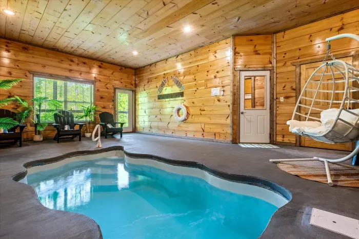 Private indoor pool in a woodsy cabin with loungers & egg swing