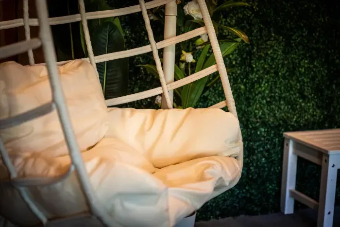 Plush hanging chair by a lush plant wall—your serene reading nook.